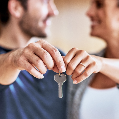 Una pareja recibiendo las llaves de su propiedad