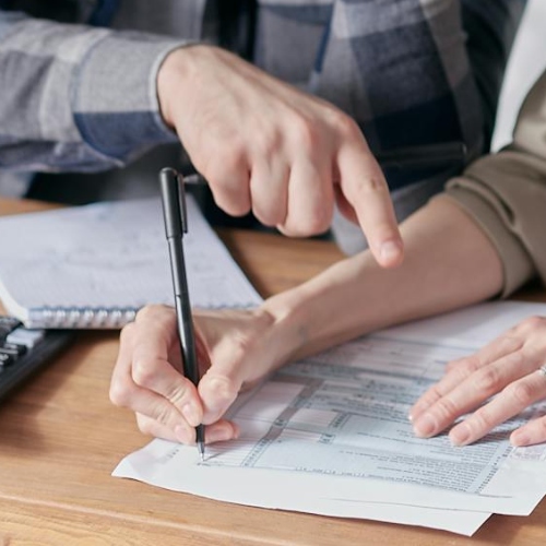 Dos personas firmando un contrato